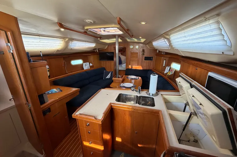 Slide: The Image of Interior of a 2002 Hunter 356 sailboat featuring a cozy living area and kitchen. - 27