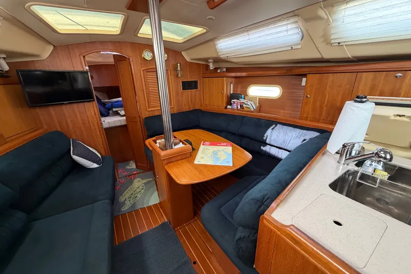 Slide: The Image of Interior of a 2002 Hunter 356 sailboat with cozy seating and wooden finishes. - 16