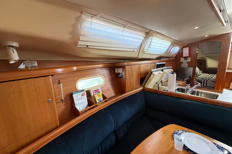 Slide: The Image of Interior of a 2002 Hunter 356 sailboat with cozy seating and kitchen area. - 32