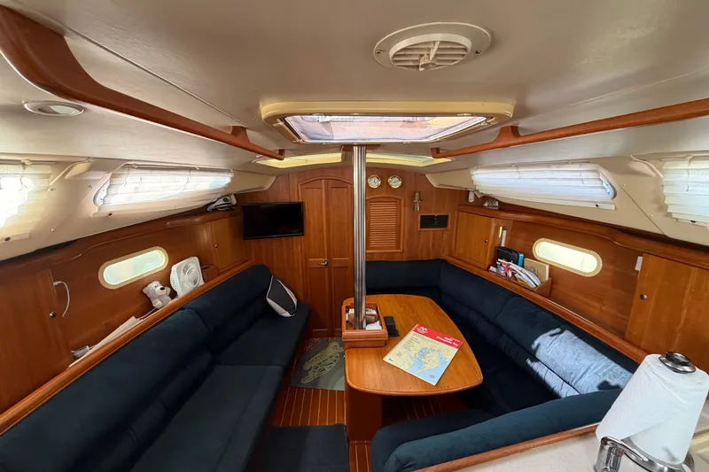 Slide: The Image of Interior of a 2002 Hunter 356 sailboat with cozy seating and wooden finishes. - 18