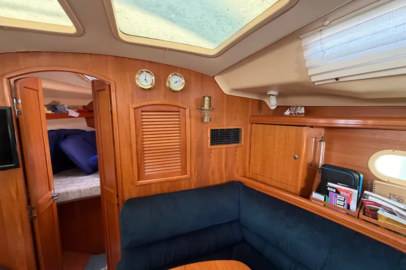 Slide: The Image of Interior of 2002 Hunter 356 sailboat with cozy seating and wooden cabinetry. - 17