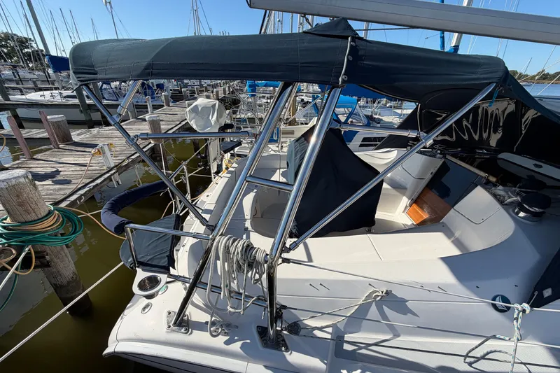 Slide: The Image of 2002 Hunter 356 sailboat docked at marina, featuring covered cockpit and rigging. - 41