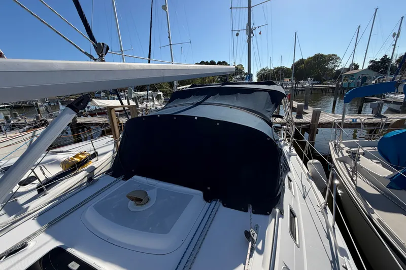 Slide: The Image of 2002 Hunter 356 sailboat docked at marina, featuring a covered cockpit and clear blue sky. - 10