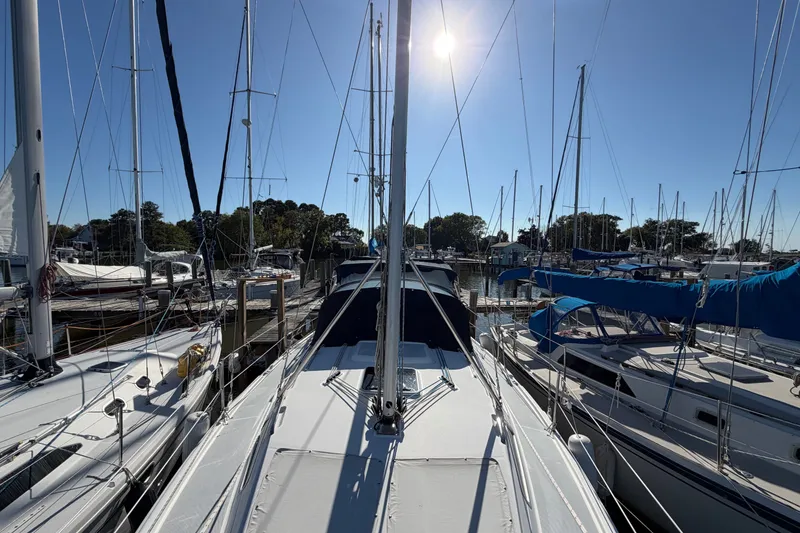 Slide: The Image of 2002 Hunter 356 sailboat docked in a sunny marina, surrounded by other boats. - 7