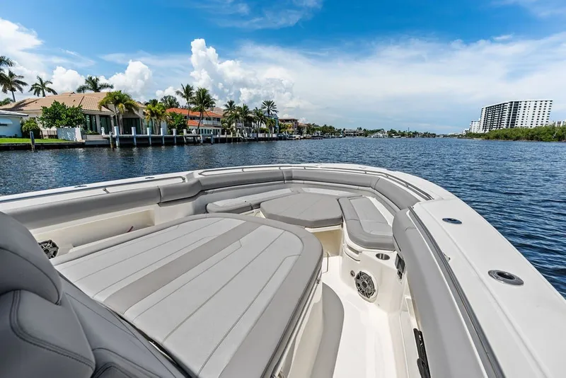 Slide: The Image of 2023 Boston Whaler 380 Outrage boat on a scenic waterfront with luxury homes. - 23