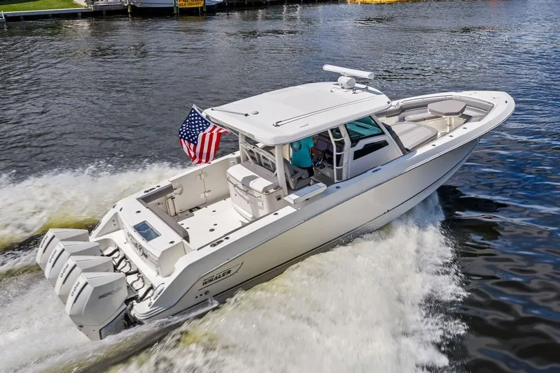 Slide: The Image of 2023 Boston Whaler 380 Outrage cruising on water with American flag. - 1
