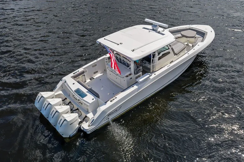 Slide: The Image of 2023 Boston Whaler 380 Outrage boat cruising on water, featuring triple outboard engines. - 12