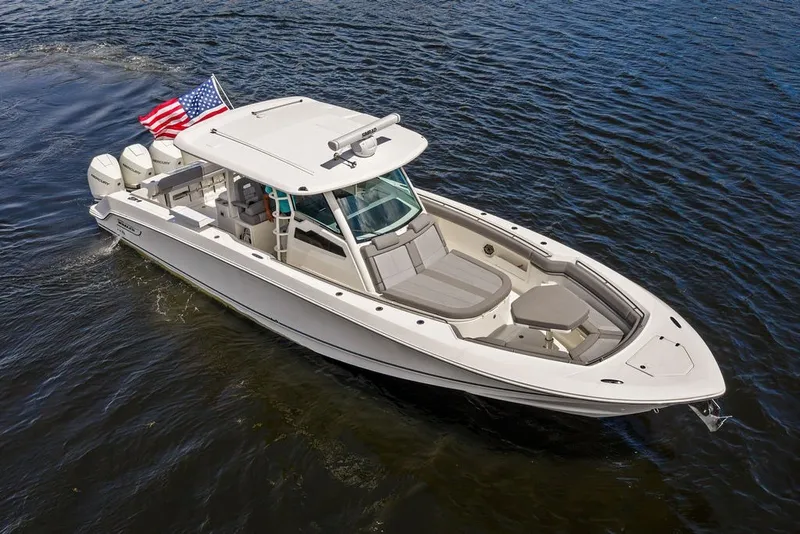 Slide: The Image of 2023 Boston Whaler 380 Outrage boat cruising on water with American flag. - 3
