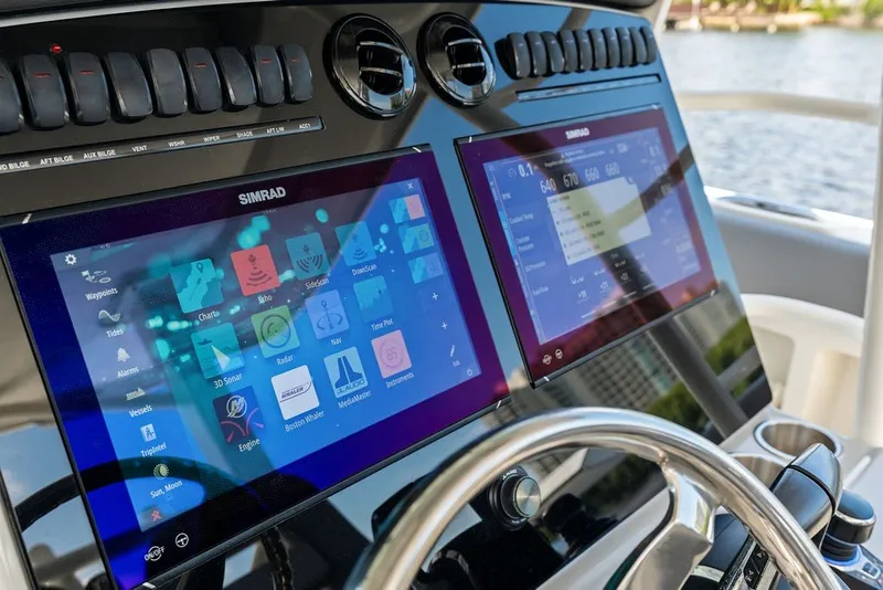 Slide: The Image of 2023 Boston Whaler 380 Outrage dashboard with dual Simrad displays and controls. - 34