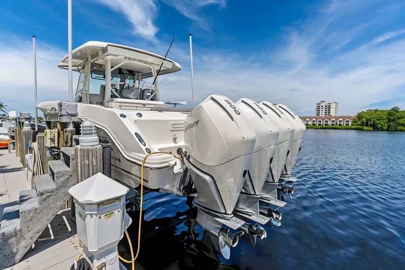 Slide: The Image of 2023 Boston Whaler 380 Outrage docked, featuring four powerful outboard engines. - 20