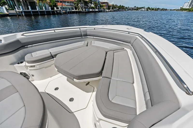 Slide: The Image of 2023 Boston Whaler 380 Outrage boat interior with cushioned seating on a calm waterway. - 25
