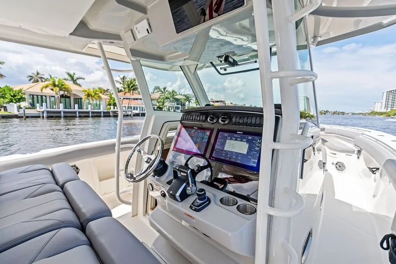 Slide: The Image of 2023 Boston Whaler 380 Outrage helm with advanced navigation systems, cruising on a sunny day. - 32