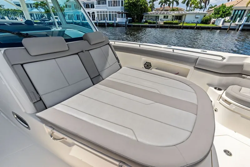 Slide: The Image of 2023 Boston Whaler 380 Outrage boat interior with luxurious seating by waterfront homes. - 26