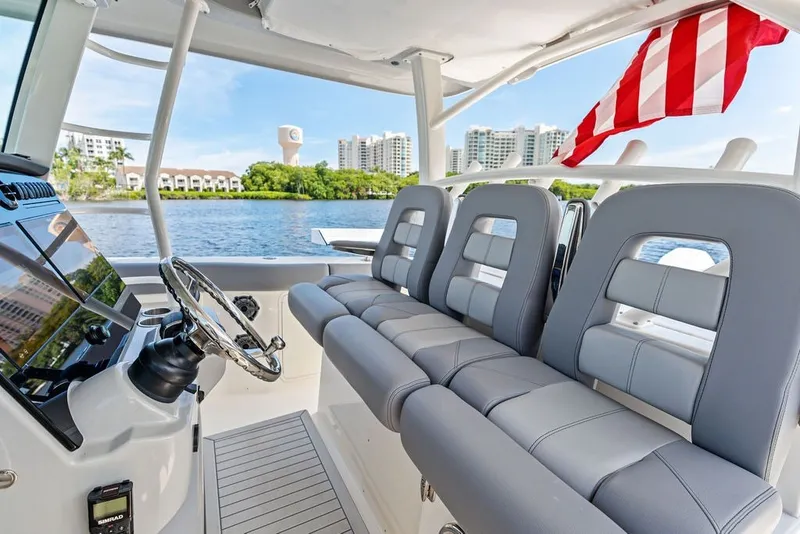 Slide: The Image of 2023 Boston Whaler 380 Outrage interior with sleek seating and modern helm, near waterfront. - 35