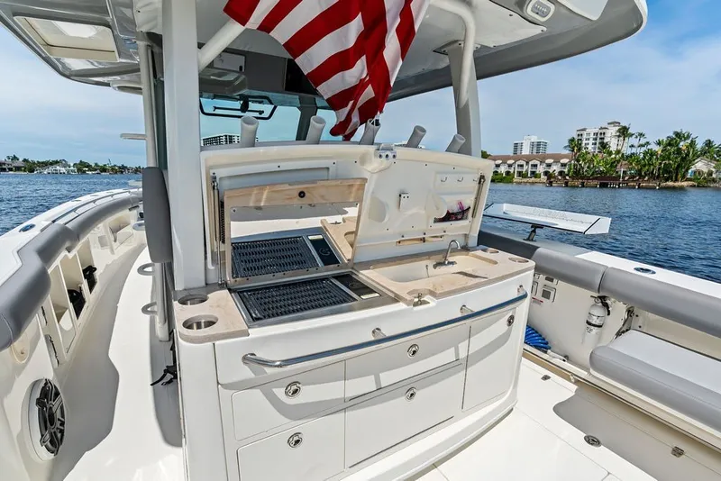 Slide: The Image of 2023 Boston Whaler 380 Outrage boat interior with kitchenette and American flag. - 41
