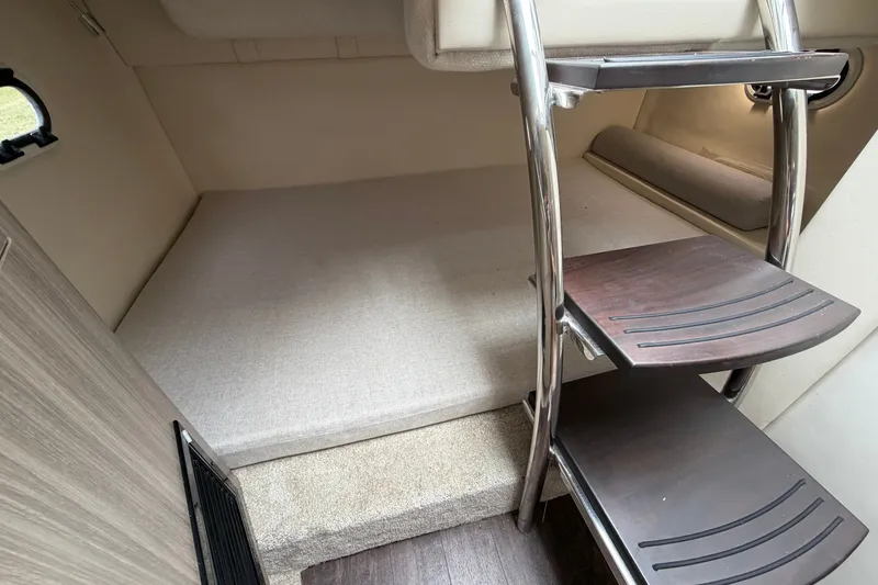 Slide: The Image of Interior cabin of 2021 Regal 26 Express boat with wooden steps and cozy sleeping area. - 34