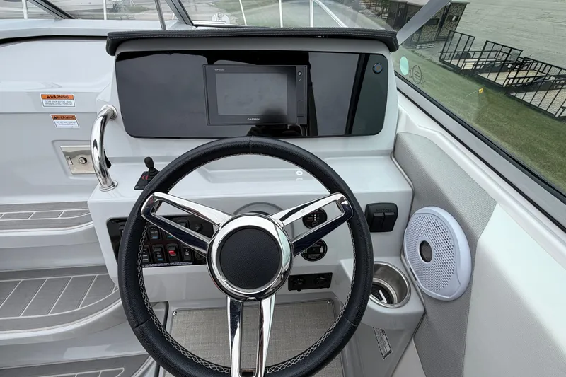 Slide: The Image of Cockpit of 2021 Regal 26 Express boat with steering wheel and control panel. - 25
