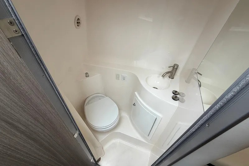 Slide: The Image of Compact bathroom in 2021 Regal 26 Express boat with toilet and sink. - 32