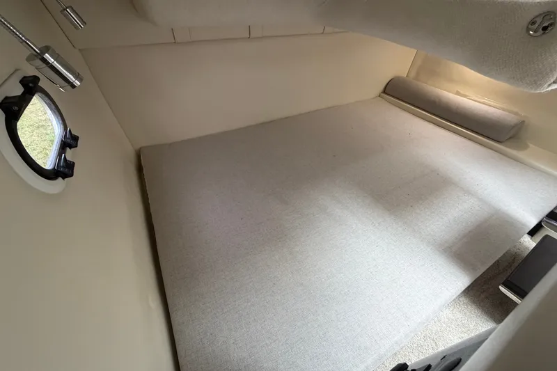 Slide: The Image of 2021 Regal 26 Express cabin interior with a comfortable bed and porthole window. - 35
