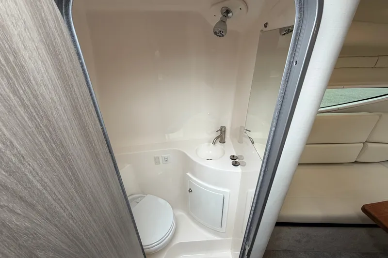 Slide: The Image of 2021 Regal 26 Express boat bathroom with compact shower, sink, and toilet. - 33
