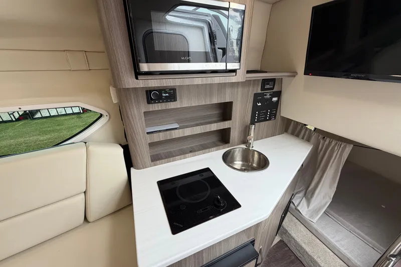 Slide: The Image of Interior of 2021 Regal 26 Express boat with kitchenette, sink, and modern appliances. - 28