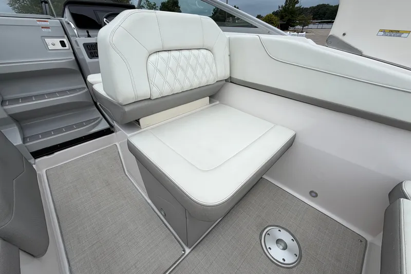 Slide: The Image of 2021 Regal 26 Express boat interior with white cushioned seating and gray flooring. - 16