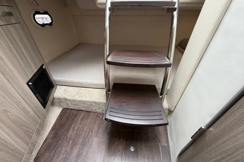 Slide: The Image of Interior of 2021 Regal 26 Express boat with wooden steps and cozy cabin space. - 36