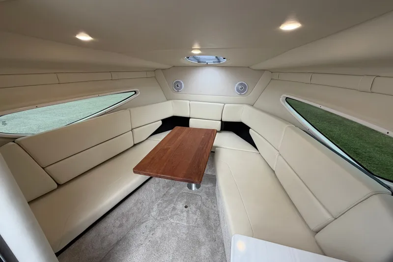 Slide: The Image of Interior of 2021 Regal 26 Express boat with beige seating and wooden table. - 26