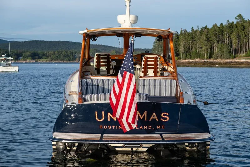 Slide: The Image of 2018 Hinckley Picnic Boat 34 MKII on water, displaying American flag, scenic background. - 31