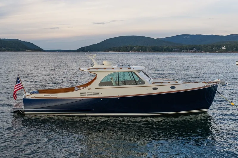 Slide: The Image of 2018 Hinckley Picnic Boat 34 MKII on serene water with scenic mountain backdrop. - 3