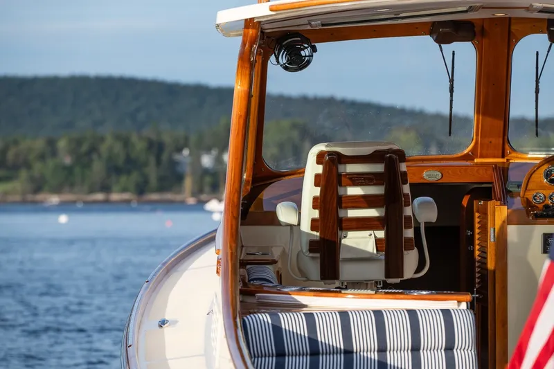 Slide: The Image of 2018 Hinckley Picnic Boat 34 MKII interior with scenic water and forest backdrop. - 30