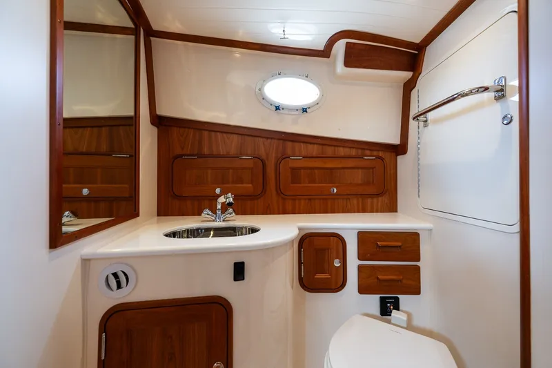 Slide: The Image of Luxurious 2018 Hinckley Picnic Boat 34 MKII bathroom with wood accents and modern fixtures. - 25