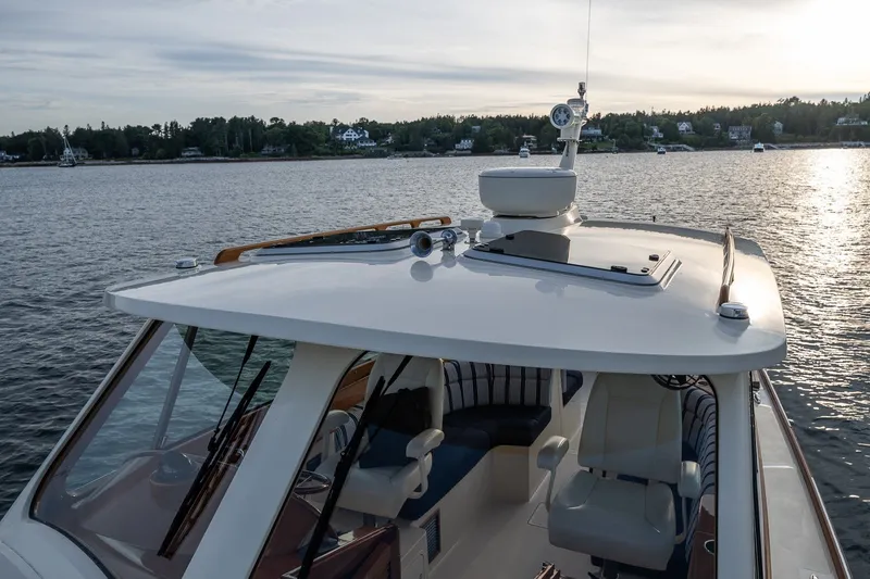 Slide: The Image of 2018 Hinckley Picnic Boat 34 MKII cruising on a serene lake at sunset. - 8