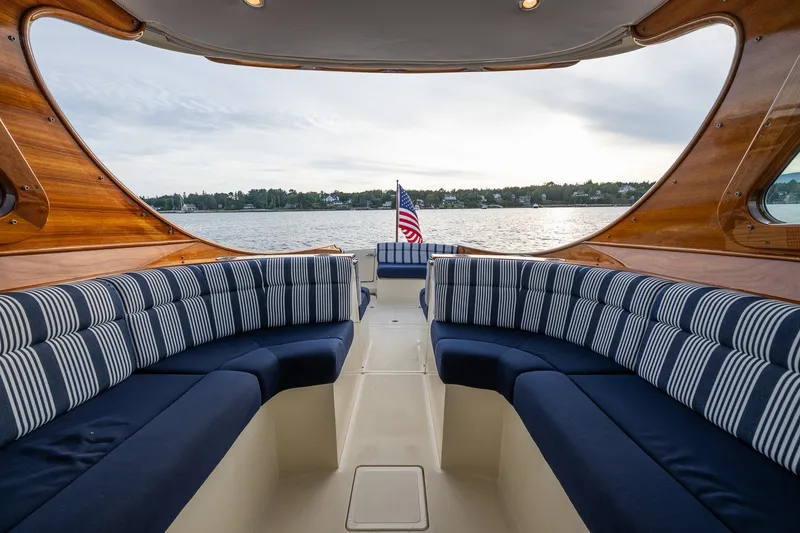 Slide: The Image of Luxurious interior of 2018 Hinckley Picnic Boat 34 MKII with striped seating, overlooking serene waters. - 14
