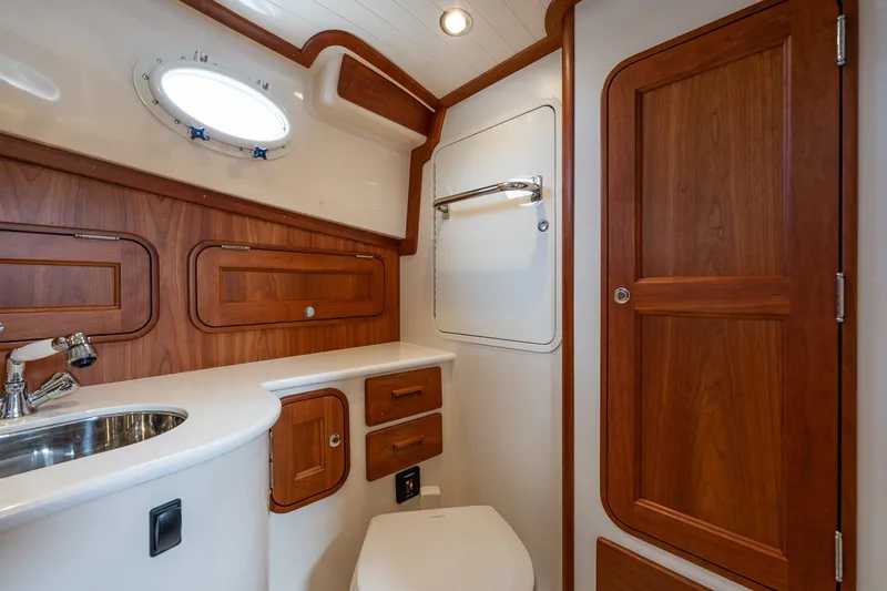Slide: The Image of Luxurious 2018 Hinckley Picnic Boat 34 MKII bathroom with wood accents and stainless steel fixtures. - 26