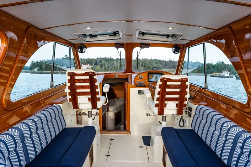 Slide: The Image of Interior of 2018 Hinckley Picnic Boat 34 MKII with striped seating and wooden accents. - 16