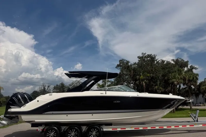 Slide: The Image of 2019 Sea Ray SLX 310 Outboard boat on trailer under blue sky. - 1