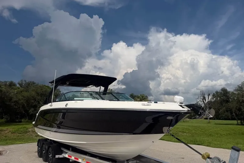 Slide: The Image of 2019 Sea Ray SLX 310 Outboard boat on trailer under cloudy sky. - 5