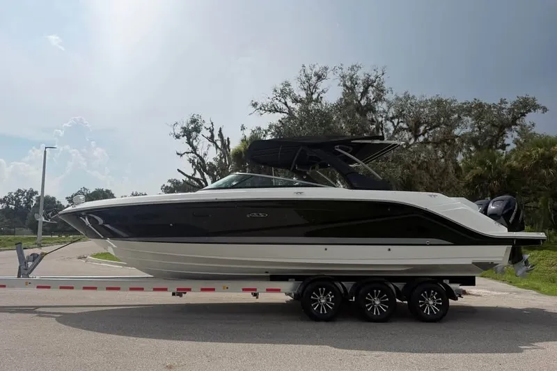 Slide: The Image of 2019 Sea Ray SLX 310 Outboard boat on trailer, parked outdoors. - 2