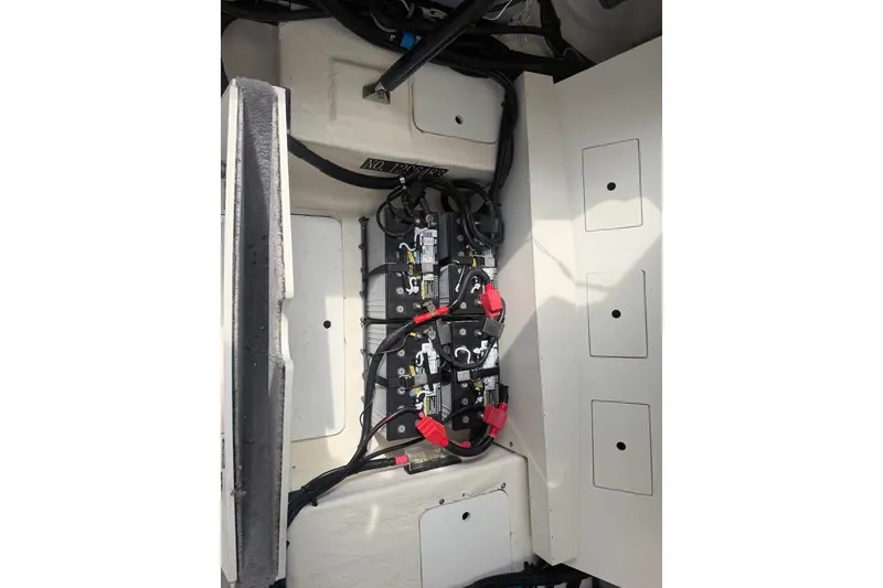 Slide: The Image of 2019 Sea Ray SLX 310 Outboard battery compartment with wiring and connections. - 17