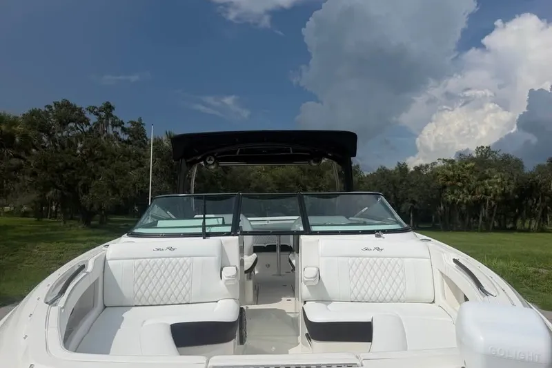 Slide: The Image of 2019 Sea Ray SLX 310 Outboard boat with white seating, set against a scenic backdrop. - 10