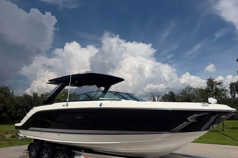 Slide: The Image of 2019 Sea Ray SLX 310 Outboard boat on trailer under a cloudy sky. - 3