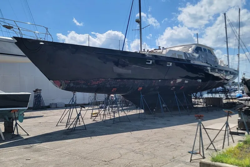 The Image of Custom Robb Ladd Pilothouse Cutter 98 PH Motorsailer, 1989, on dry dock under clear sky. - 0