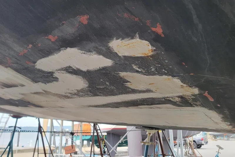 Slide: The Image of Hull of 1989 Custom Rob Ladd PH Motorsailer Cutter under repair, showing patches and rust. - 65