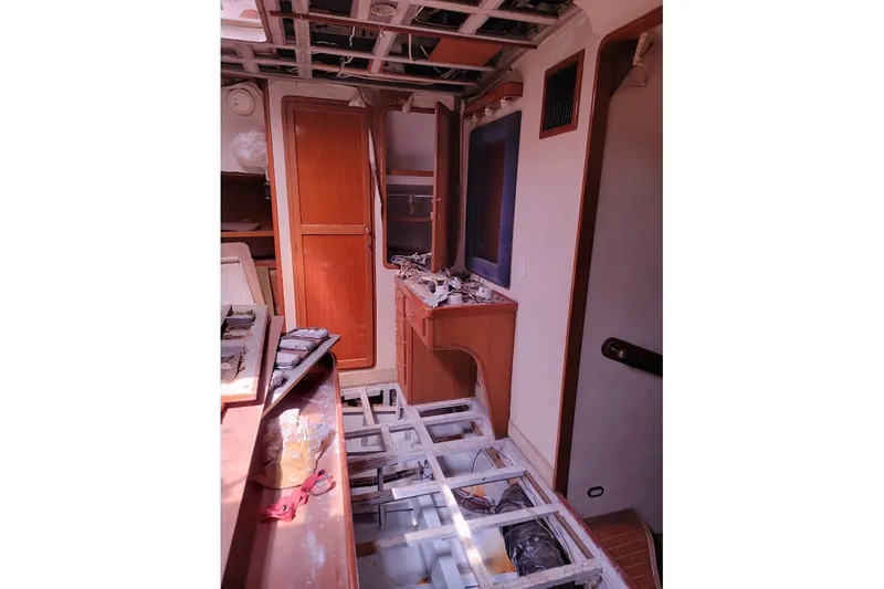 Slide: The Image of Interior of 1989 Custom Robb Ladd Pilothouse Cutter under renovation, showing wooden cabinetry and exposed flooring. - 9