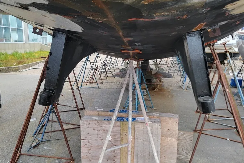 Slide: The Image of Underneath view of a 1989 Custom Rob Ladd PH Motorsailer Cutter on stands. - 60