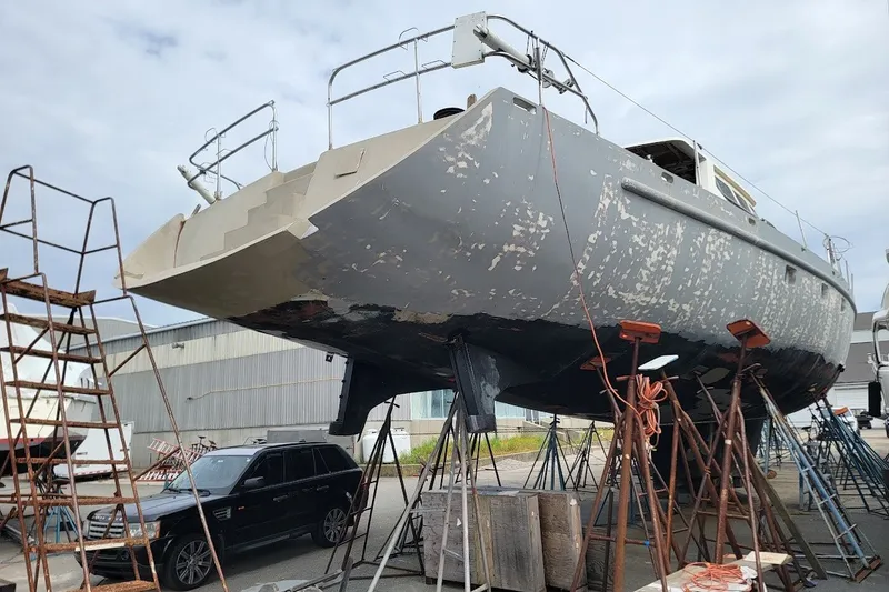 Slide: The Image of 1989 Custom Rob Ladd PH Motorsailer Cutter under restoration, elevated on stands in a shipyard. - 31