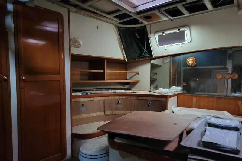 Slide: The Image of Interior of 1989 Custom Rob Ladd PH Motorsailer Cutter, featuring wooden cabinetry and unfinished surfaces. - 44