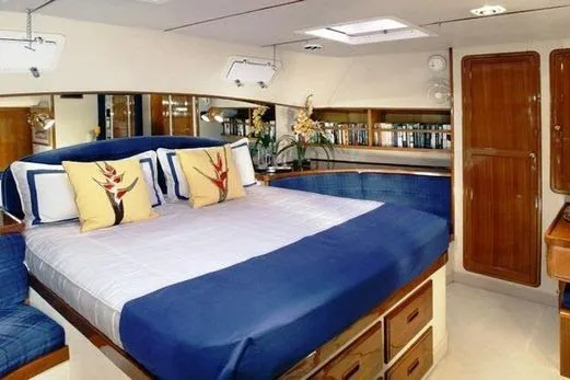 Slide: The Image of The image shows a luxurious cabin with a large bed, blue accents, and wooden furnishings. - 7