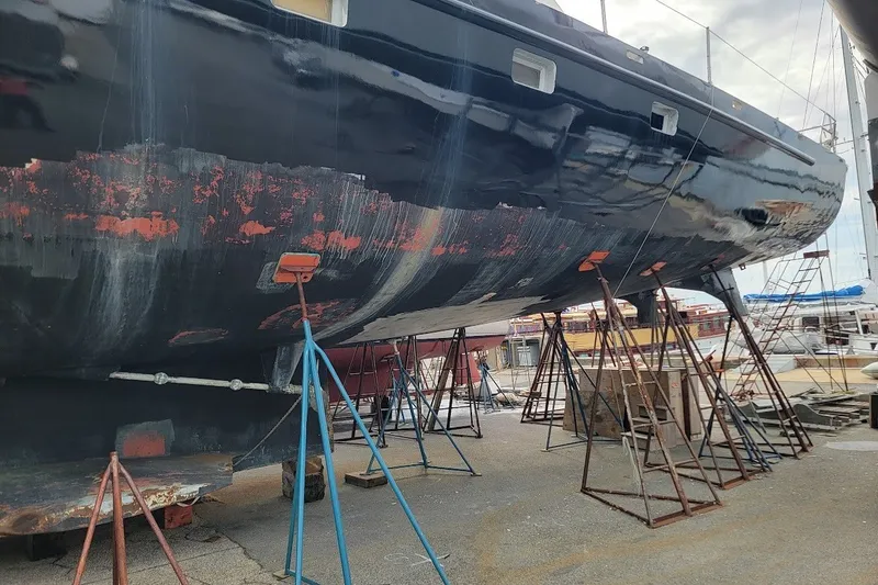 Slide: The Image of 1989 Custom Rob Ladd PH Motorsailer Cutter under restoration, supported by stands in a boatyard. - 69